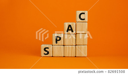 SPAC, special purpose acquisition company symbol. Businessman holds cubes with word 'SPAC' on beautiful orange background, copy space. Business and SPAC, special purpose acquisition company concept. 82691508