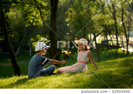Children's date, boy gives bouquet to a girl Children's date, boy gives bouquet to a girl 82691640