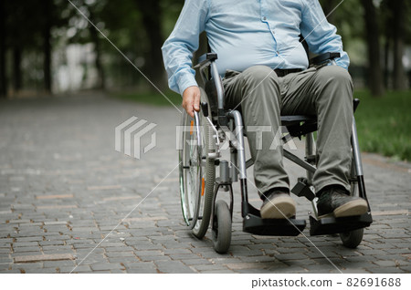 Adult disabled man in wheelchair resting in park 82691688