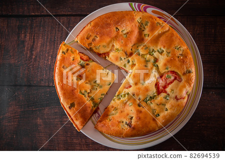 A piece of cake with chicken, herbs and tomatoes on a plate. Homemade delicious food for diet. 82694539