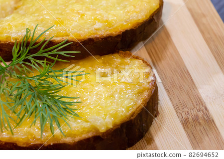 Hot sandwiches with melted cheese and herbs on wooden background Hot sandwiches with melted cheese and herbs on wooden background 82694652