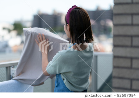 Housewife hanging laundry on the balcony 82697084