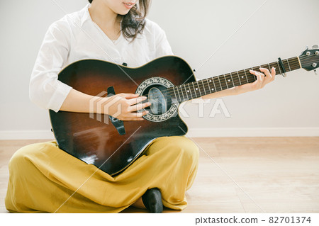 Woman playing the guitar Woman playing the guitar People playing the guitar in the room Woman playing the guitar Woman playing the guitar People playing the guitar in the room 82701374
