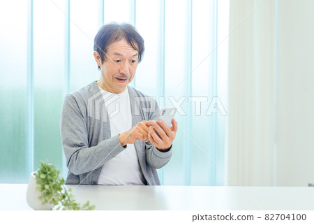 Middle-aged and older men using smartphones (app, surprised) 82704100
