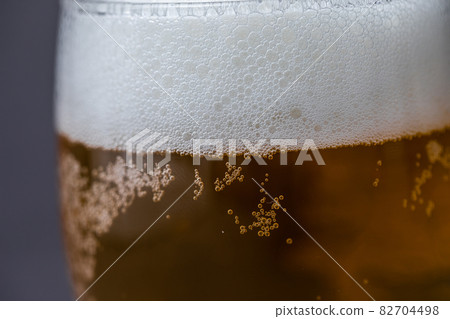 Beer that shines on a gray background Beer poured into a glass 82704498
