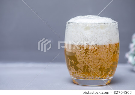 Beer that shines on a gray background Beer poured into a glass Beer that shines on a gray background Beer poured into a glass 82704503