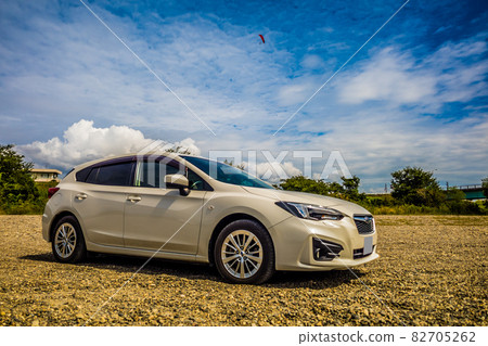 藍天中飛翔的滑翔傘，碎石路上停著的白色汽車 82705262