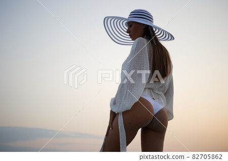 Stylish sensual woman in beachwear and hat Stylish sensual woman in beachwear and hat 82705862