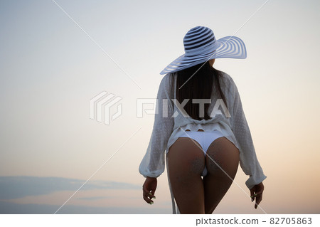 Stylish sensual woman in beachwear and hat Stylish sensual woman in beachwear and hat 82705863