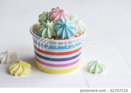 Small colorful meringues in the  paper bowl 82707216