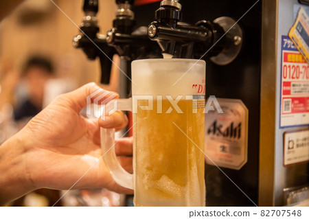 Draft beer poured into a mug Draft beer poured from a beer server 82707548
