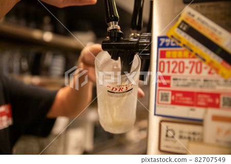 Draft beer poured into a mug Draft beer poured from a beer server 82707549