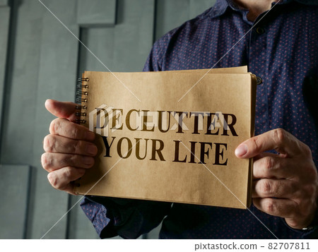 Man shows page with words declutter your life. 82707811