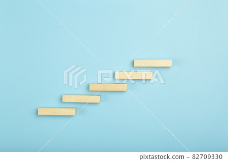 Business growth, development plan concept and business analytics background. Wooden steps of blocks on a blue background as financial and career growth, increase in monetary income and economic 82709330