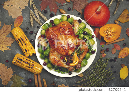 Thanksgiving turkey or chicken for a festive dinner. Food table background with autumn seasonal specialties for Thanksgiving Day. Fried chicken with pumpkin, vegetables and autumn decor on a wooden Thanksgiving turkey or chicken for a festive dinner. Food table background with autumn seasonal specialties for Thanksgiving Day. Fried chicken with pumpkin, vegetables and autumn decor on a wooden 82709341