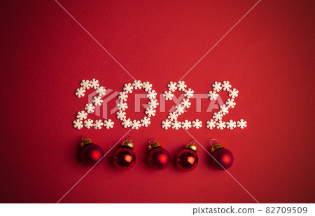 New Year 2022. Creative number written in white snowflakes on a red background for design. New Year 2022 concept New Year 2022. Creative number written in white snowflakes on a red background for design. New Year 2022 concept 82709509