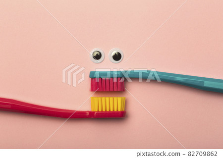 Kids toothbrushes of different colors on a pink background. Teeth and oral hygiene for children Kids toothbrushes of different colors on a pink background. Teeth and oral hygiene for children 82709862