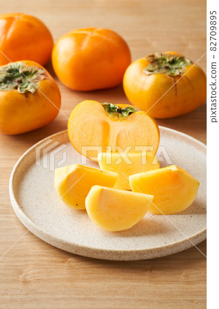 Persimmons cut and served on a plate Persimmons cut and served on a plate 82709895