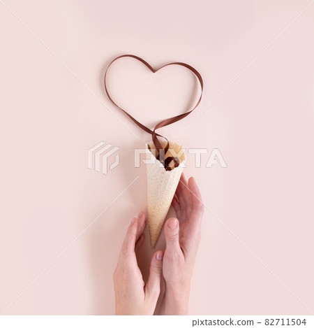 Waffle cone with brown ribbon in the shape of heart 82711504