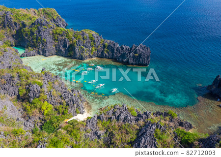 Aerial drone view azure sea and of tourist boats around the beautiful big and small lagoons in El 82712003