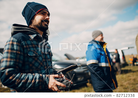 Man pilot controlling quadcopter drone with remote controller pad Man pilot controlling quadcopter drone with remote controller pad 82712338