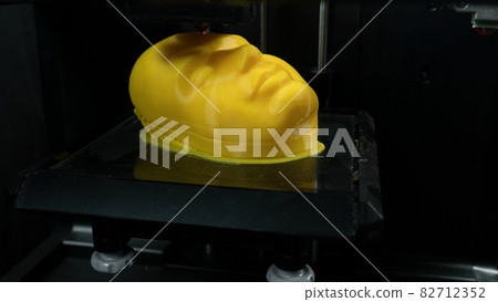 Modern technologies, 3d printer prints the yellow model of the head, the process of printing the face model on the 3d printer. Modern technologies, 3d printer prints the yellow model of the head, the process of printing the face model on the 3d printer. 82712352