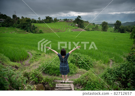 The scenery of a happy traveler standing in a terraced rice field at Mae Chaem, Chiang Mai, Thailand The scenery of a happy traveler standing in a terraced rice field at Mae Chaem, Chiang Mai, Thailand 82712657
