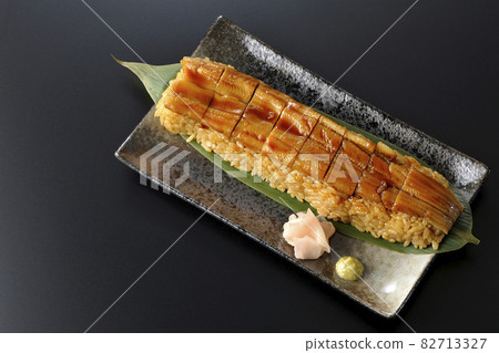 A bird's-eye view of sushi, gari and wasabi on a black background 82713327