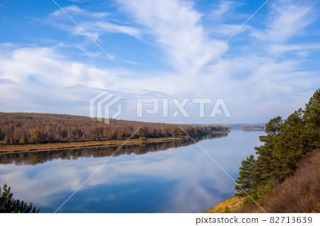 Beautiful, wide river autumn among the woods. Calm and quiet place with autumn colors. In the middle of the river island. View from the top to the distance Beautiful, wide river autumn among the woods. Calm and quiet place with autumn colors. In the middle of the river island. View from the top to the distance 82713639