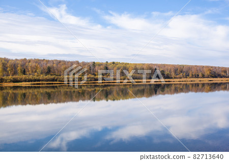 Beautiful, wide river autumn among the woods. Calm and quiet place with autumn colors. In the middle of the river island. View from the top to the distance 82713640