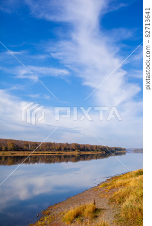 Beautiful, wide river autumn among the woods. Calm and quiet place with autumn colors. In the middle of the river island. View from the top to the distance 82713641