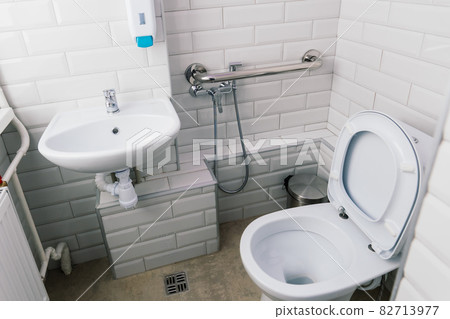 View of a new toilet and bathroom interior for hospital, white and clean View of a new toilet and bathroom interior for hospital, white and clean 82713977