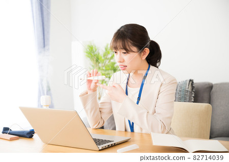 A woman showing a thermometer in an online clinic A woman showing a thermometer in an online clinic 82714039