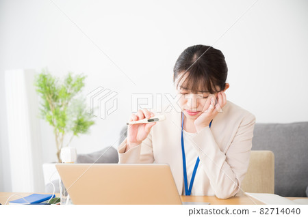 A woman showing a thermometer in an online clinic A woman showing a thermometer in an online clinic 82714040
