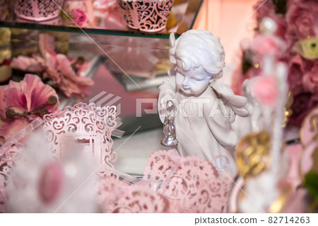 Delicious desserts at the wedding candy bar in the buffet area: statuette, figurine, angels. 82714263