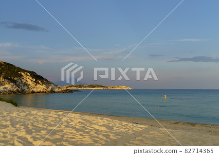 Sea shore with sea mountain view and man surfing on sup board on sunny day 82714365