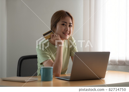 Happy woman doing online shopping at home, woman hand holding credit card and using laptop computer Happy woman doing online shopping at home, woman hand holding credit card and using laptop computer 82714750