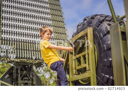A little boy is studying military equipment. No war A little boy is studying military equipment. No war 82714923