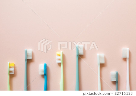 Colorful toothbrushes on pink background. top view, copy space 82715153
