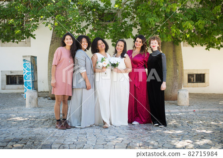 Portrait of smiling brides and guests at wedding Portrait of smiling brides and guests at wedding 82715984