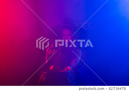 Child girl witch preparing a potion in the cauldron at halloween holidays. Copy space. 82716478
