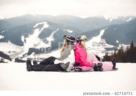 Girls snowboarding in the mountains with the snowboard Girls snowboarding in the mountains with the snowboard 82718751