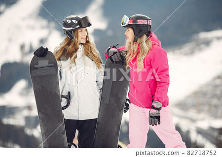 Girls snowboarding in the mountains with the snowboard Girls snowboarding in the mountains with the snowboard 82718752
