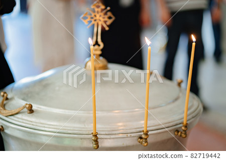burning candles on baptismal bowl in the cathedral. Orthodox Church. burning candles on baptismal bowl in the cathedral. Orthodox Church. 82719442