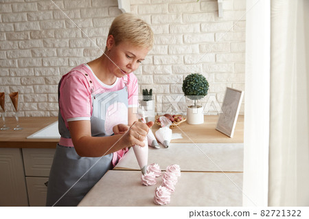 Confectioner making marshmallow desserts with pastry bag 82721322
