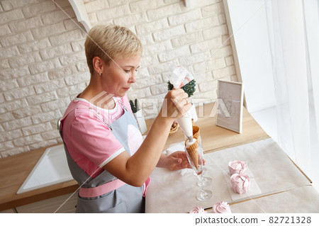 Confectioner making marshmallow desserts with pastry bag 82721328