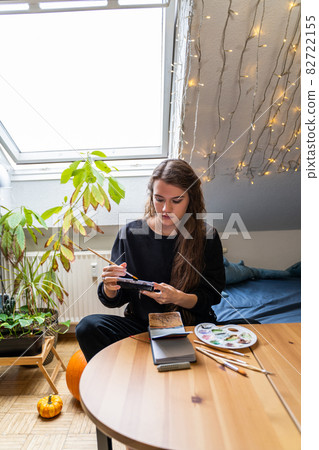 Brunette woman drawing nature landscape on paper notebook with watercolor Brunette woman drawing nature landscape on paper notebook with watercolor 82722155