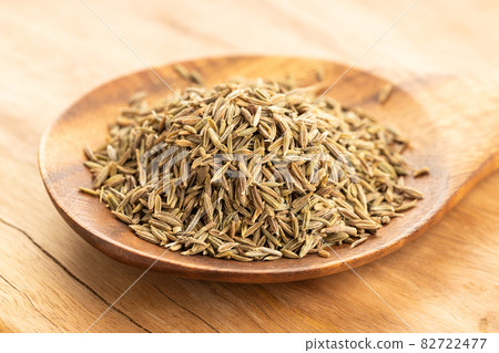 Cumin seeds on wooden spoon on table. Cuminum cyminum 82722477