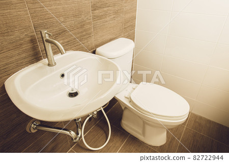Hand wash basin and toilet bowl in the home bathroom. Hand wash basin and toilet bowl in the home bathroom. 82722944
