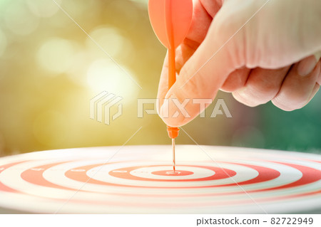 Business target concept, male hand holding arrow dart at center targeting hit highest point. 82722949